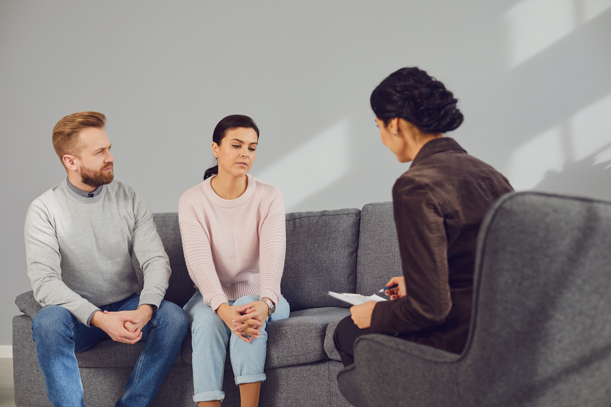 Psychologist at a psychotherapy session with a couple in the room. Man and woman visit a psychologist in an office.